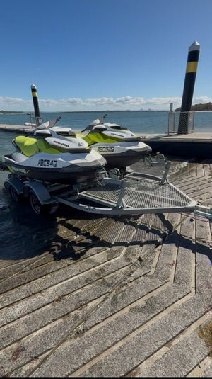 Two Sea-Doo jet skis secured on a trailer fitted with Snap-D stainless steel D shackles.